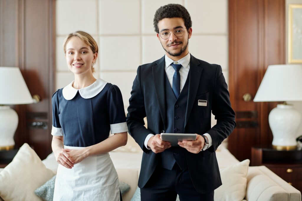 Young successful staff of luxurious five star hotel standing in room