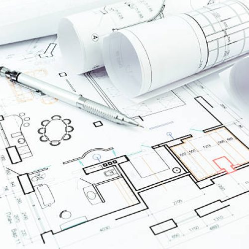 Rolls of blueprints and architectural drawings with pencil